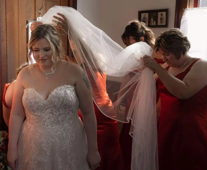 Bridesmaids helping the bride with her veil before the ceremony