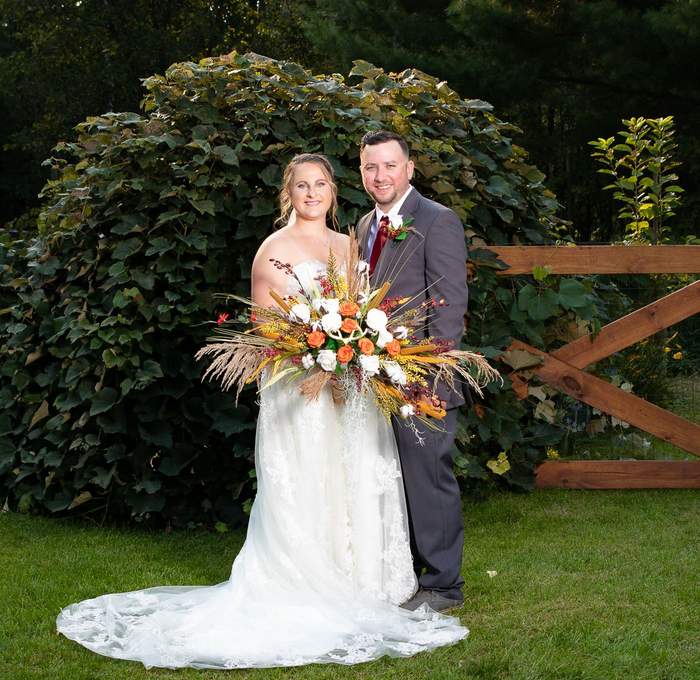 Bride and groom portrait by a garden hedge
