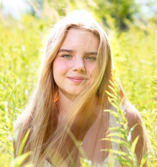 Senior portrait in tall summer grass, backlit golden light