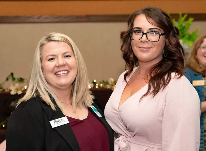 Two women smiling together at a gala reception
