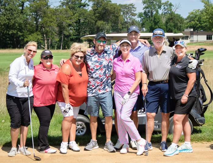 Golf outing group photo beside the cart