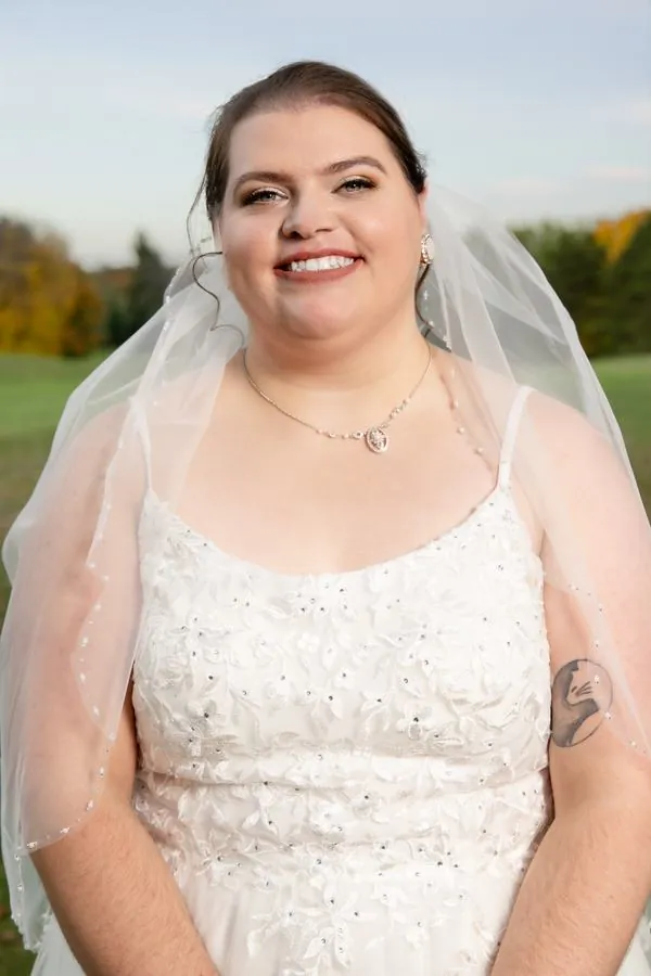 Bride in veil smiling, outdoor portrait