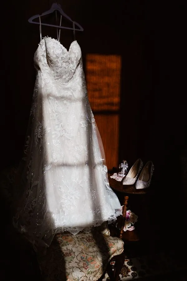 Wedding dress hanging in soft window light