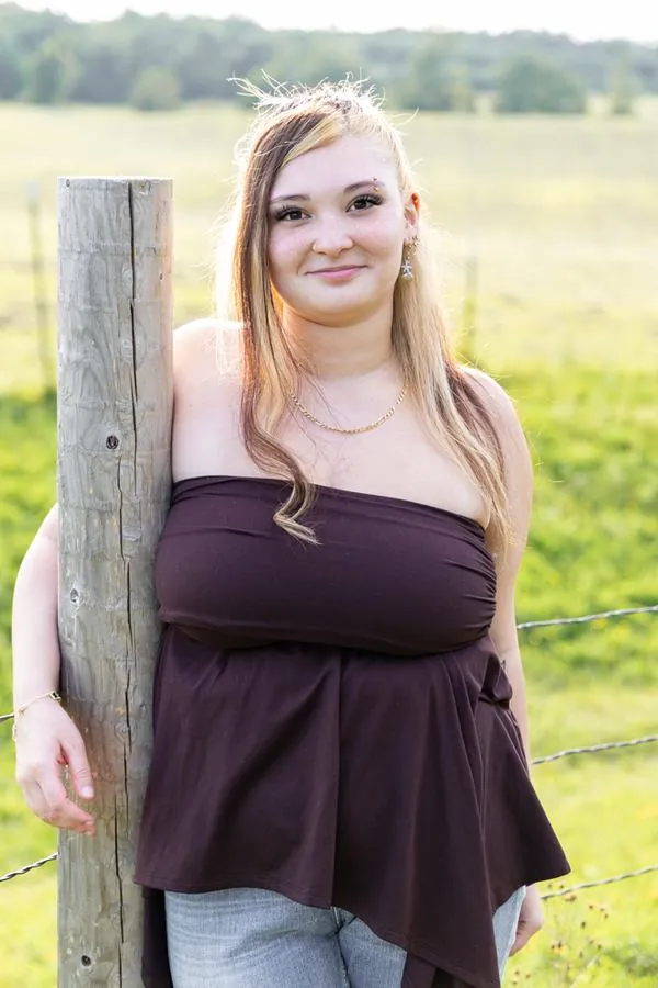 Senior portrait against a weathered wood fence