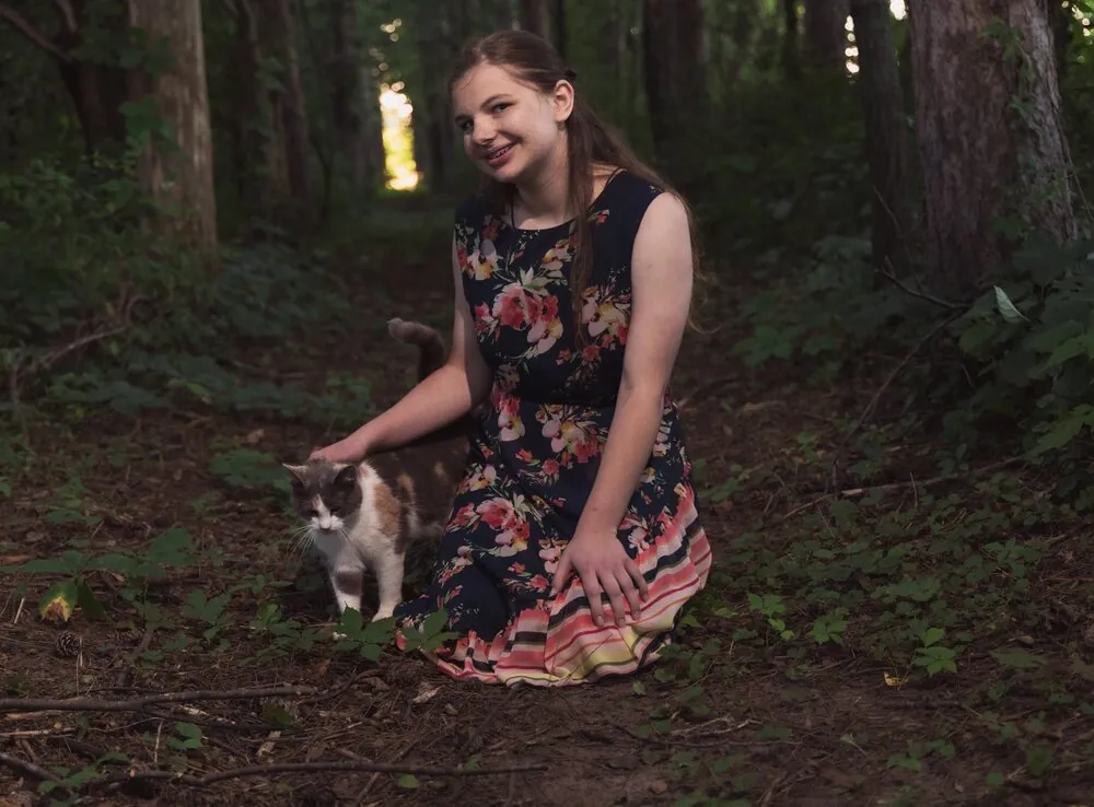 Senior portrait with her cat on a wooded trail