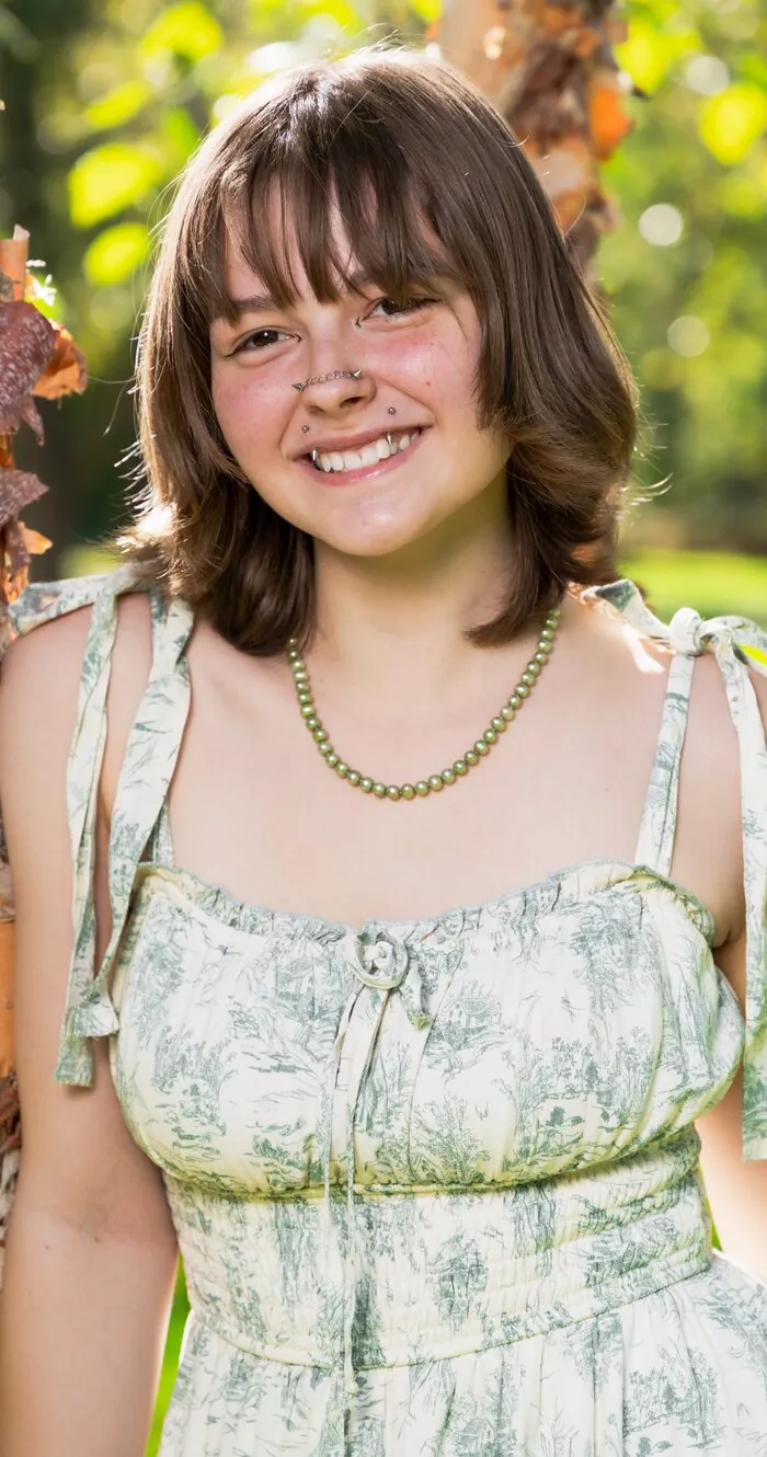 Senior portrait smiling among birch trees